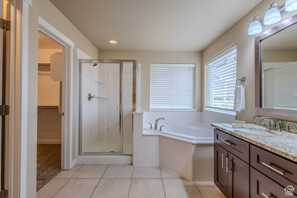 Full bath with a shower stall, vanity, a walk in closet, a bath, and recessed lighting