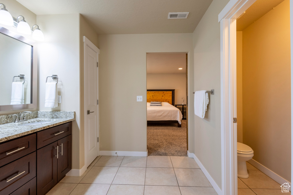 Bathroom featuring vanity, tile patterned flooring, and connected bathroom