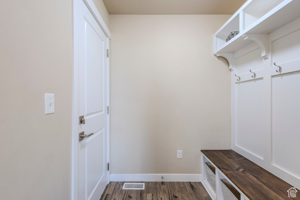 Mudroom with dark wood finished floors and baseboards