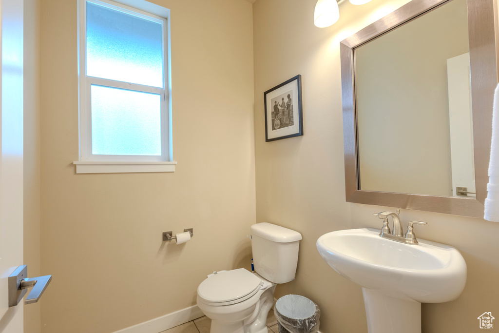 Half bath with toilet and tile patterned flooring