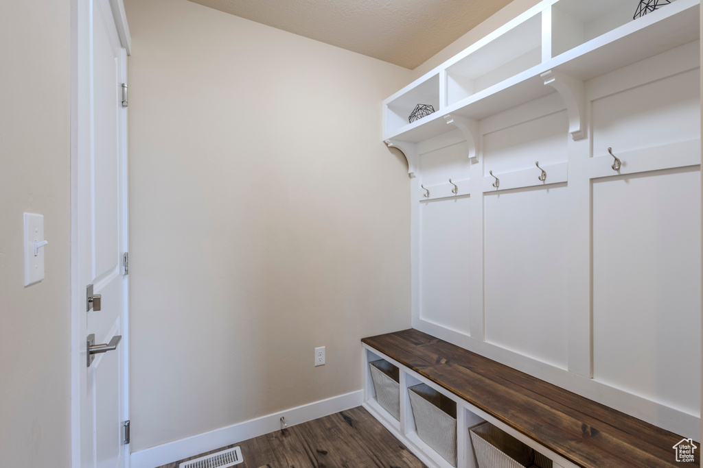 Mudroom featuring dark wood-style floors and baseboards