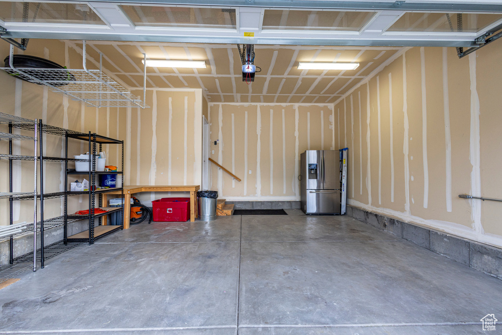 Garage featuring stainless steel refrigerator with ice dispenser