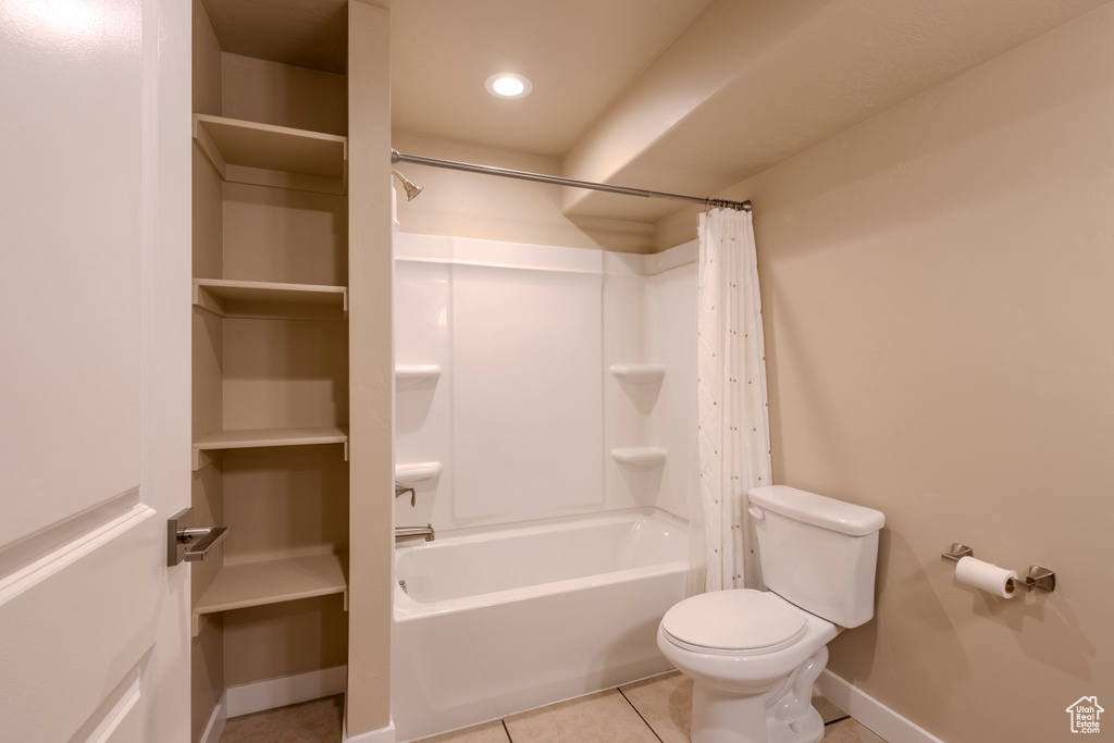 Full bath with tile patterned floors, shower / bath combo, and recessed lighting