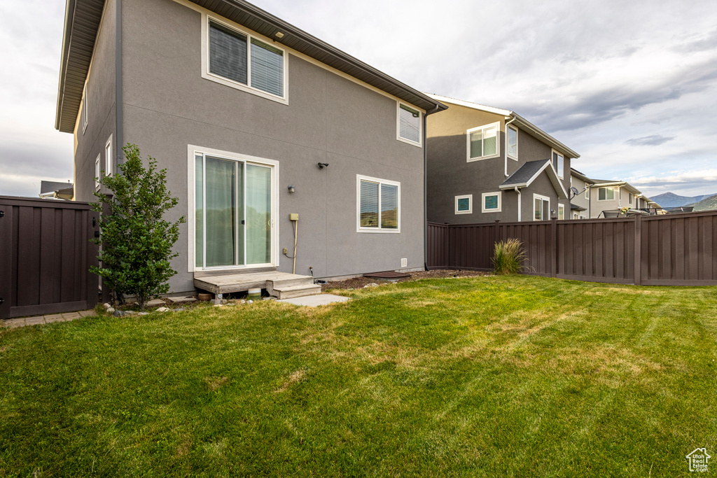 Back of property featuring a fenced backyard and stucco siding