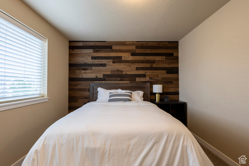 Bedroom with wood walls and carpet floors
