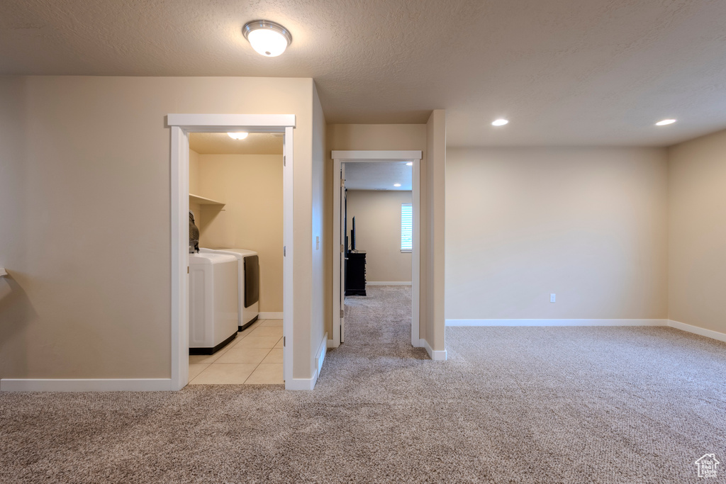 Empty room featuring washing machine and dryer, light colored carpet, and recessed lighting