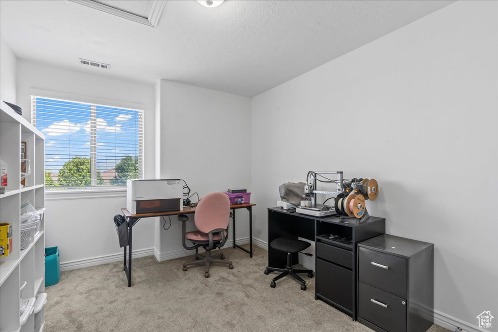 Carpeted home office featuring baseboards