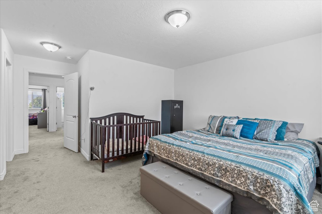 Bedroom with light colored carpet and baseboards