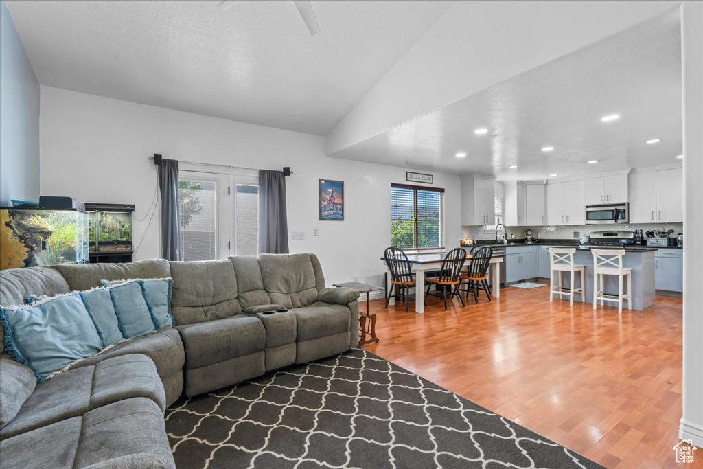 Living area featuring recessed lighting, light wood-type flooring, ceiling fan, and vaulted ceiling