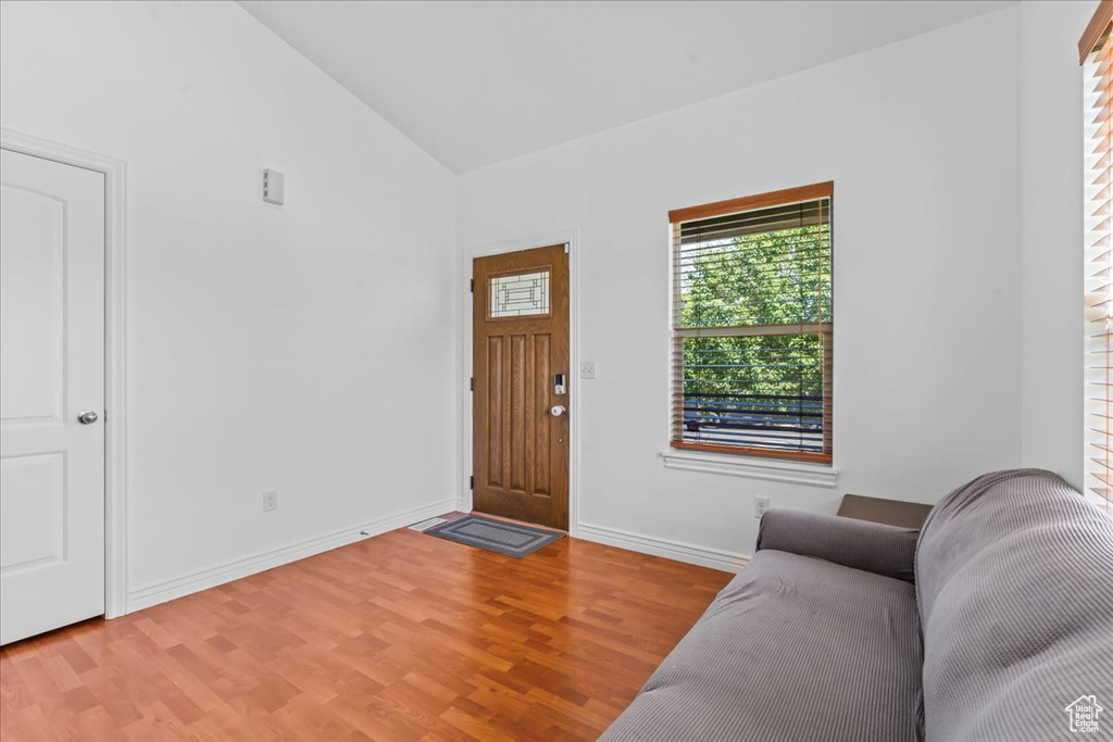 Foyer entrance featuring light wood finished floors and high vaulted ceiling
