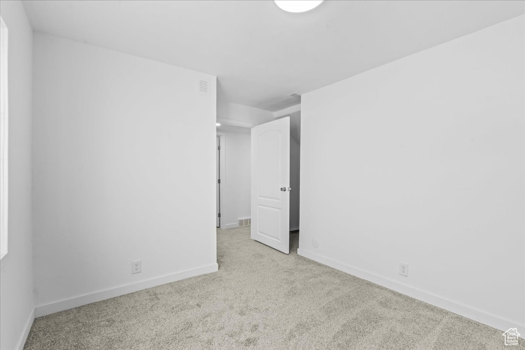 Spare room featuring carpet and baseboards