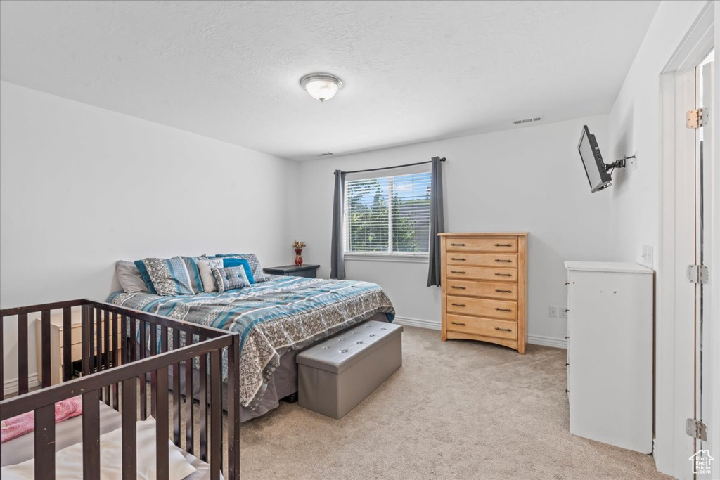 Bedroom featuring light colored carpet
