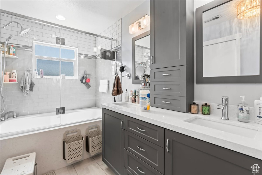 Bathroom featuring bath / shower combo with glass door, double vanity, and tile patterned floors