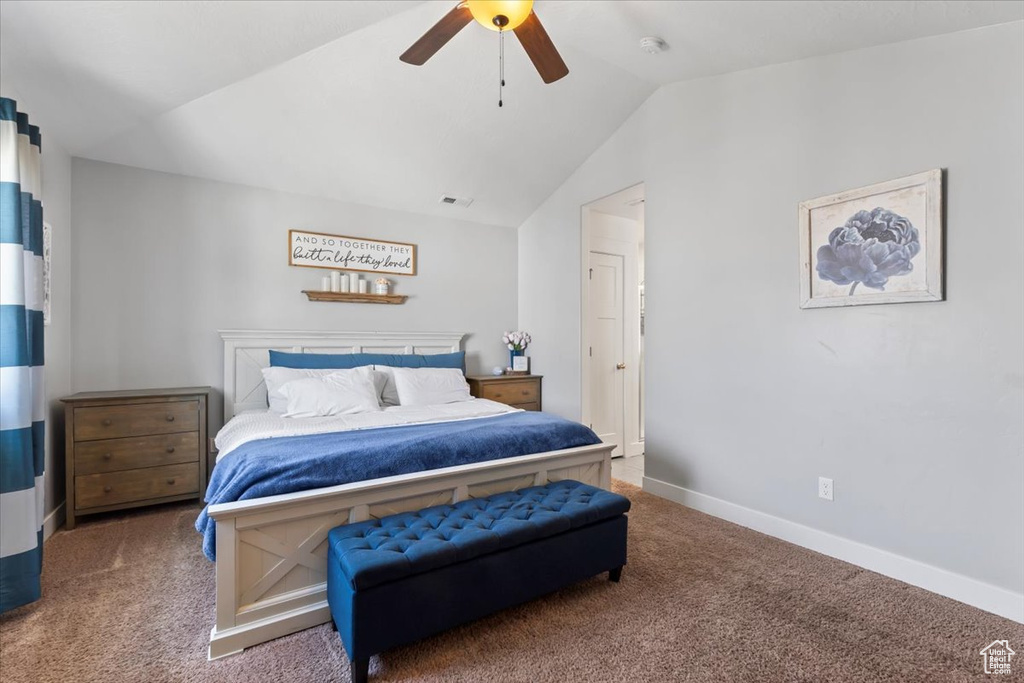 Carpeted bedroom with vaulted ceiling and ceiling fan