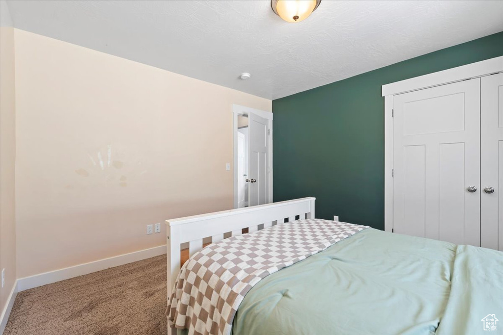 Carpeted bedroom featuring baseboards and a closet