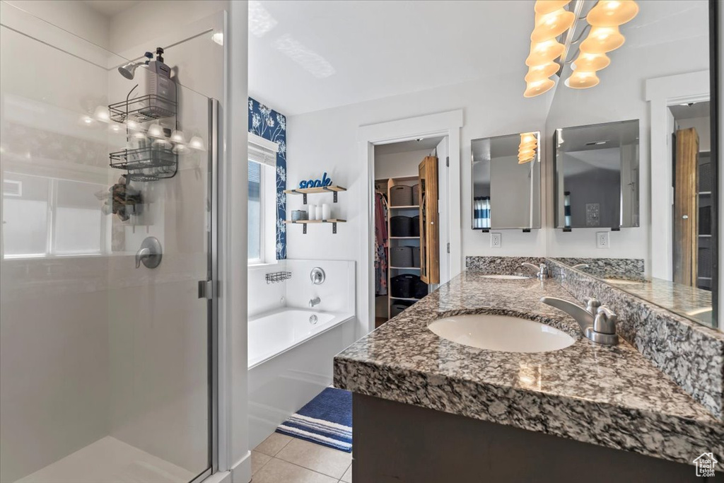 Full bath with a stall shower, double vanity, a garden tub, and tile patterned flooring