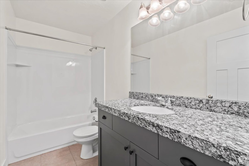 Bathroom with vanity, tub / shower combination, and tile patterned flooring