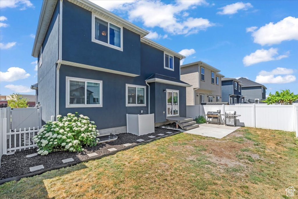 Back of property featuring a patio area, a fenced backyard, stucco siding, a gate, and a residential view