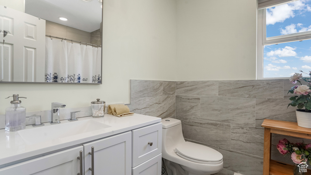 Full bathroom featuring tile walls and vanity