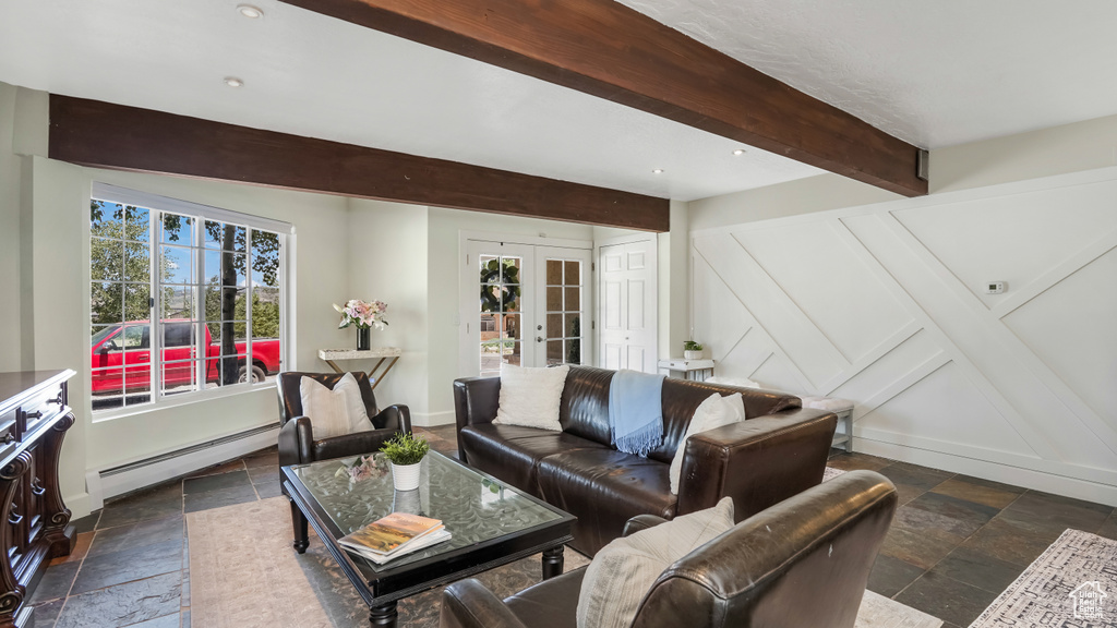 Living room with stone tile flooring, beamed ceiling, a baseboard radiator, and french doors