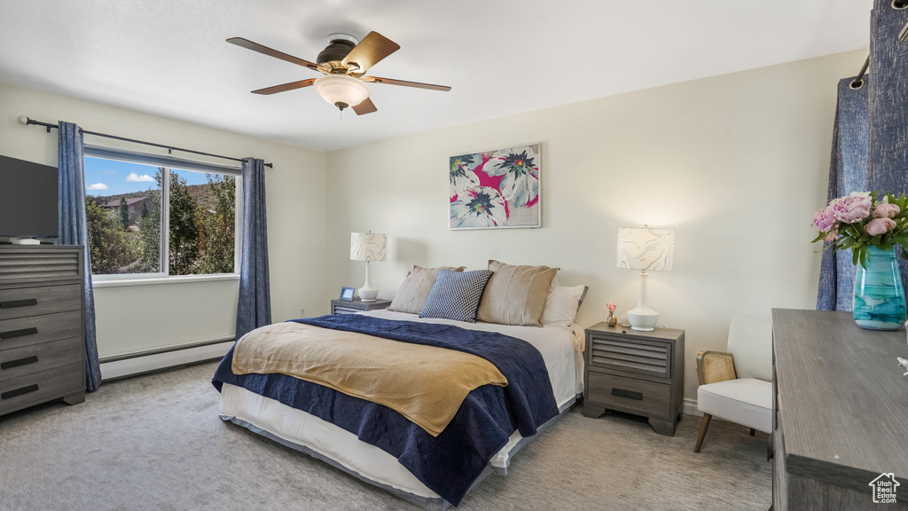 Bedroom with baseboard heating, carpet floors, and ceiling fan