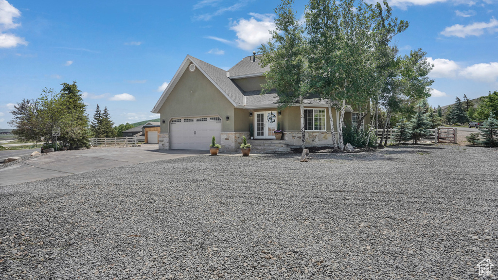 View of front of property featuring stone siding, stucco siding, concrete driveway, and an attached garage