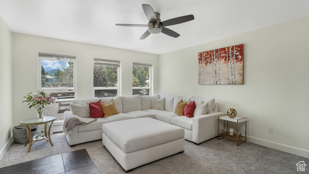 Living room featuring a ceiling fan and baseboards