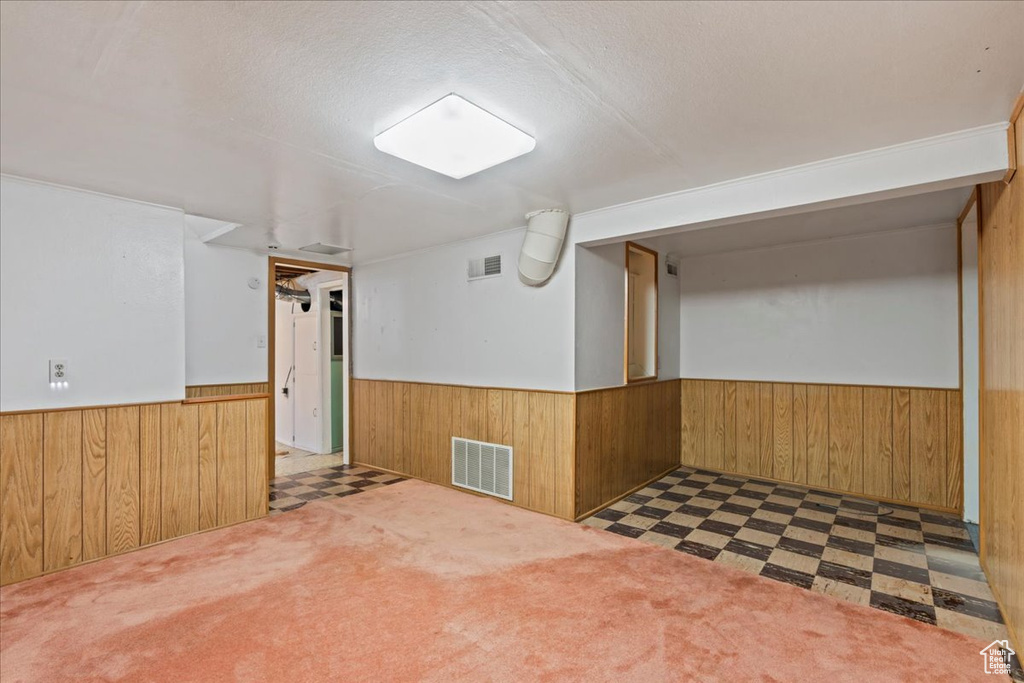 Finished below grade area featuring wainscoting, wooden walls, and tile patterned floors
