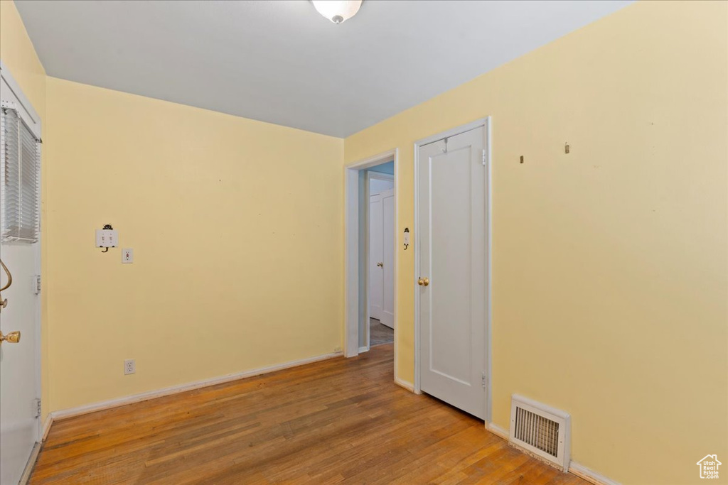 Unfurnished room with wood finished floors and baseboards