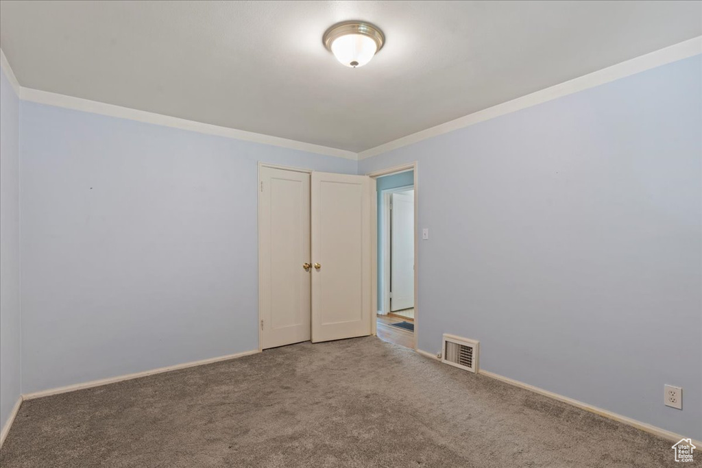 Unfurnished room with carpet floors and crown molding