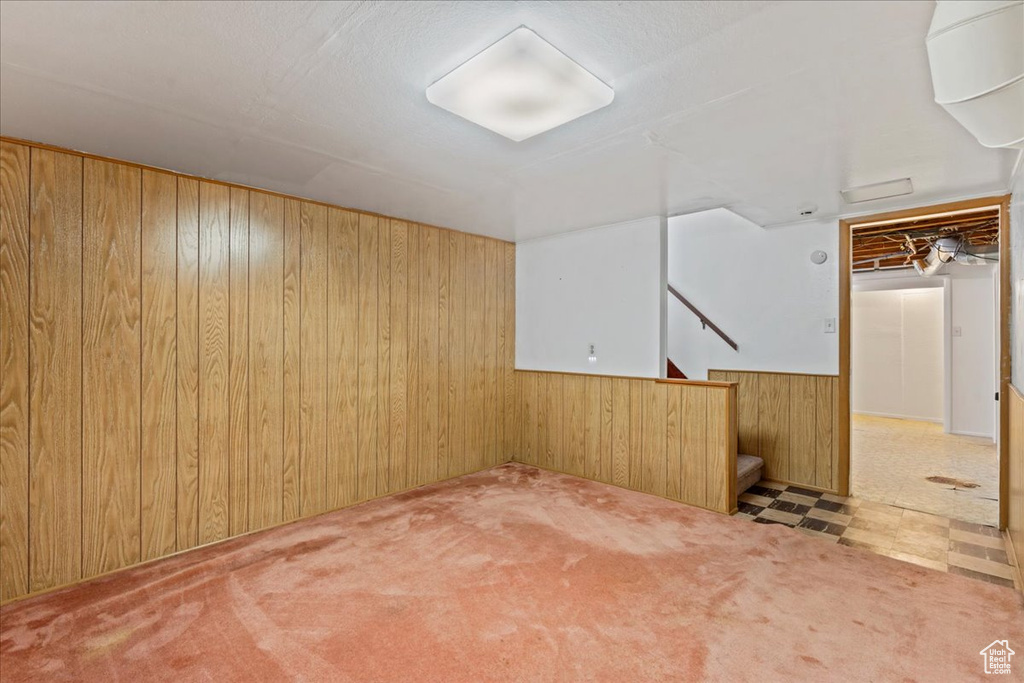 Finished below grade area with wood walls, stairway, wainscoting, and carpet floors