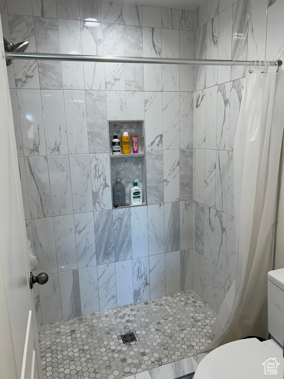 Full bath featuring toilet and a tile shower