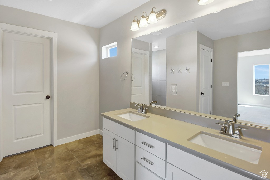 Bathroom featuring double vanity and baseboards