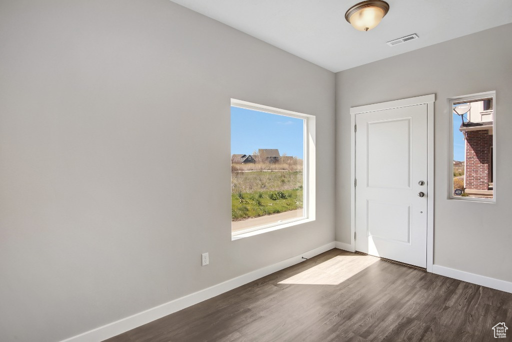 Foyer featuring dark wood-style flooring and baseboards