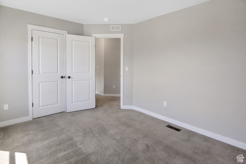 Unfurnished bedroom with carpet floors and a closet
