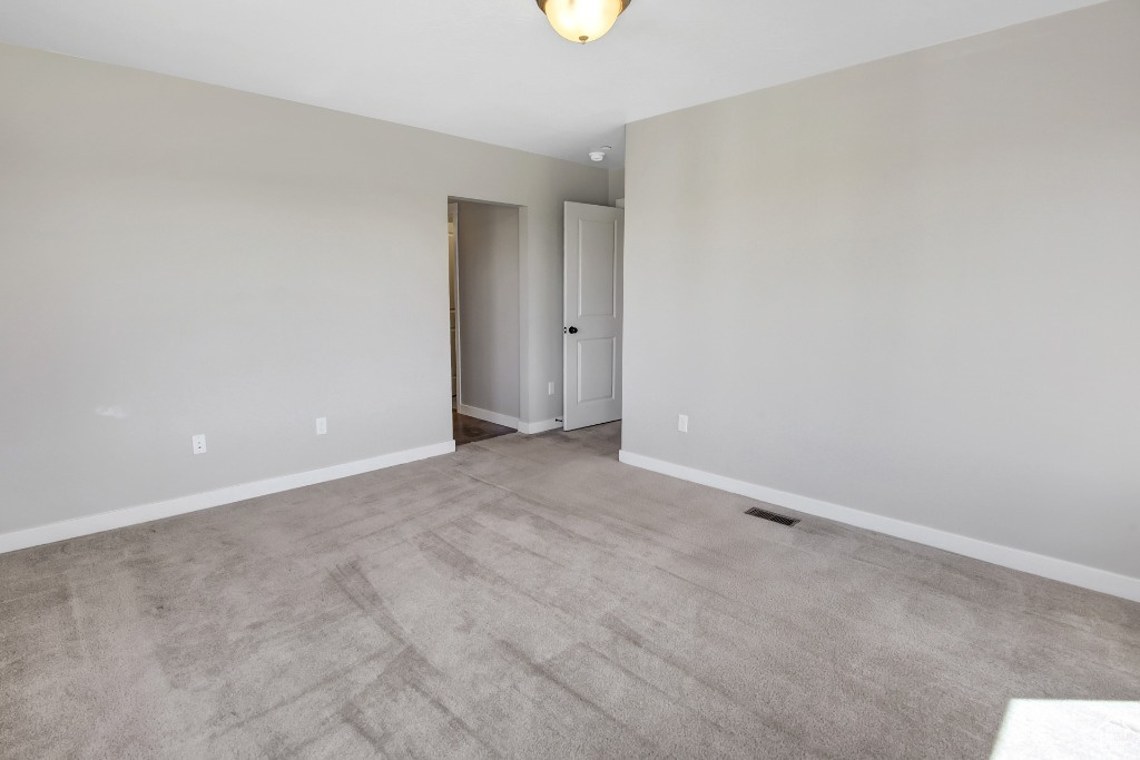 Carpeted empty room with baseboards