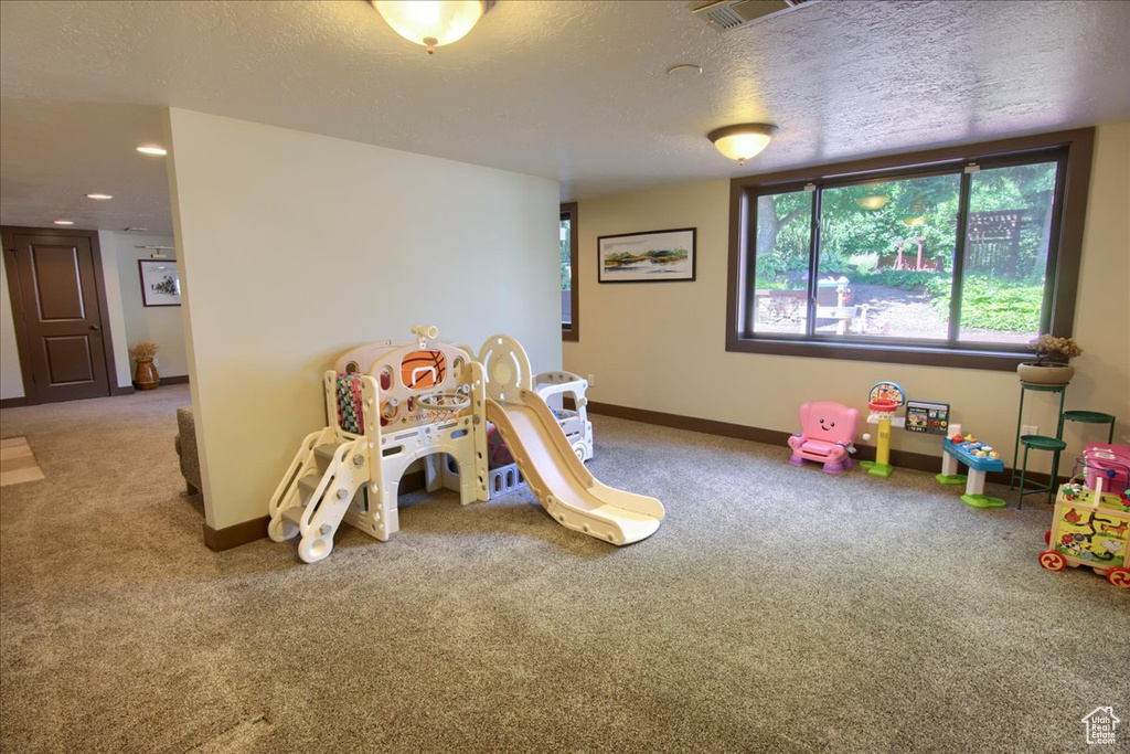 Game room with carpet flooring, a textured ceiling, and recessed lighting
