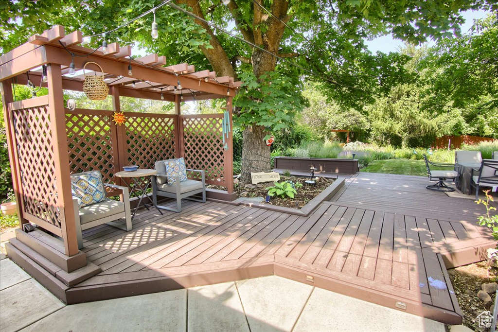 Wooden deck featuring a hot tub and a pergola