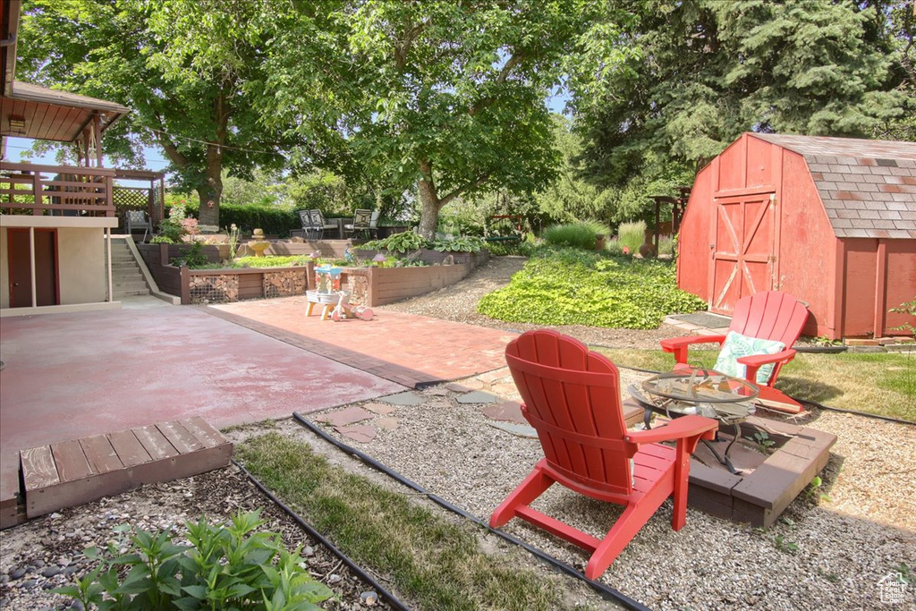 View of patio / terrace with a storage shed, stairway, and a garden