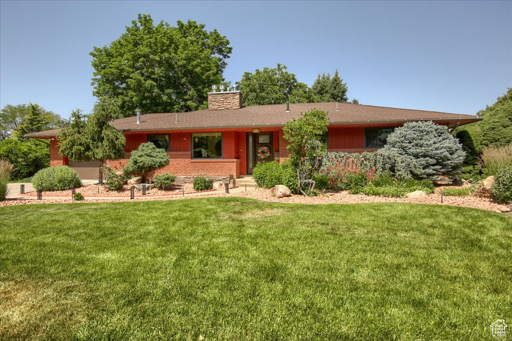 Single story home with a front lawn and a chimney