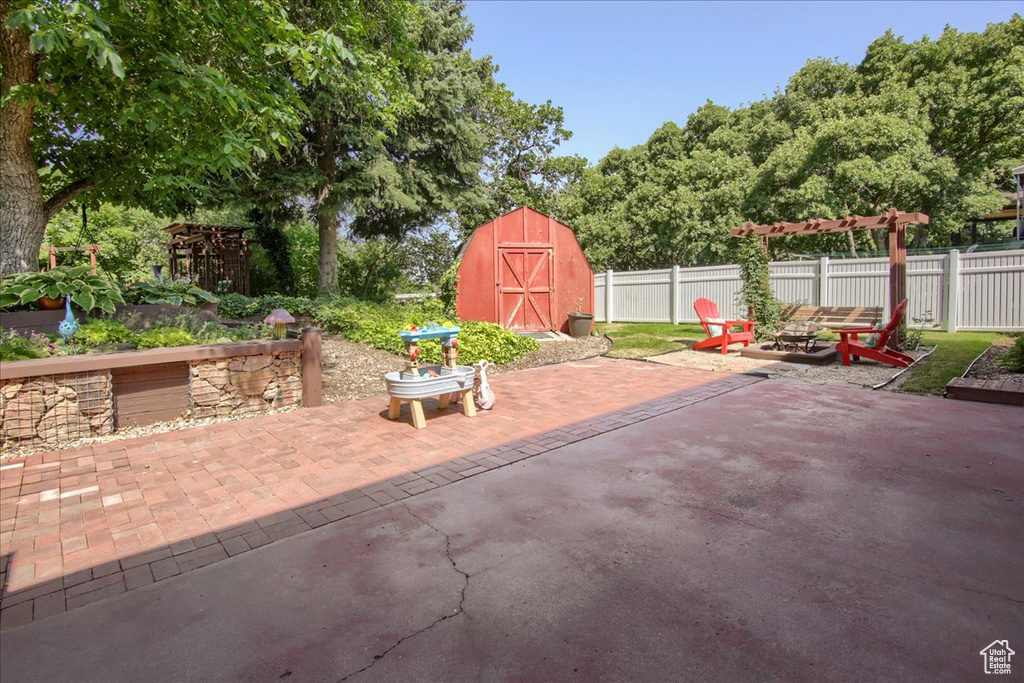 View of patio / terrace featuring a storage unit and a fire pit