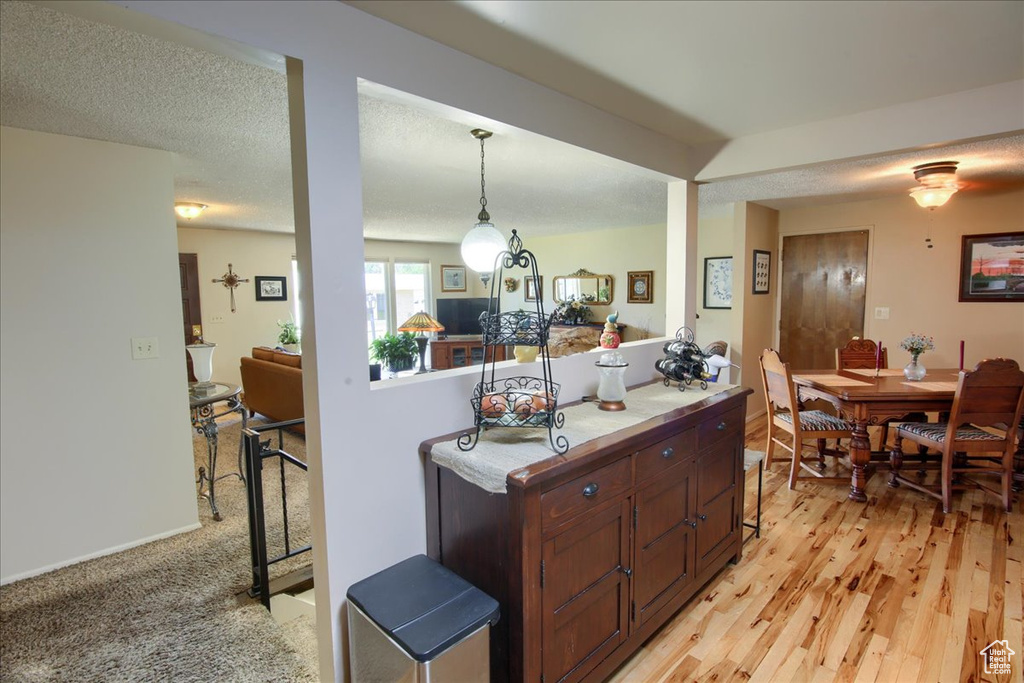 Kitchen with light countertops, pendant lighting, and light wood-style flooring