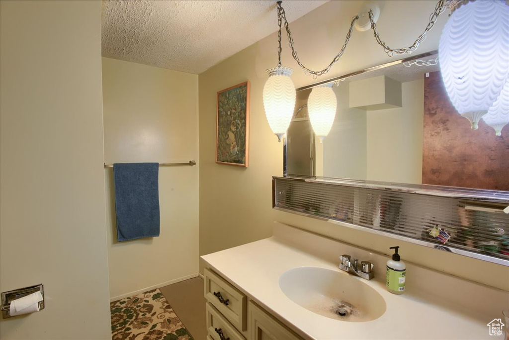 Bathroom featuring a textured ceiling and vanity