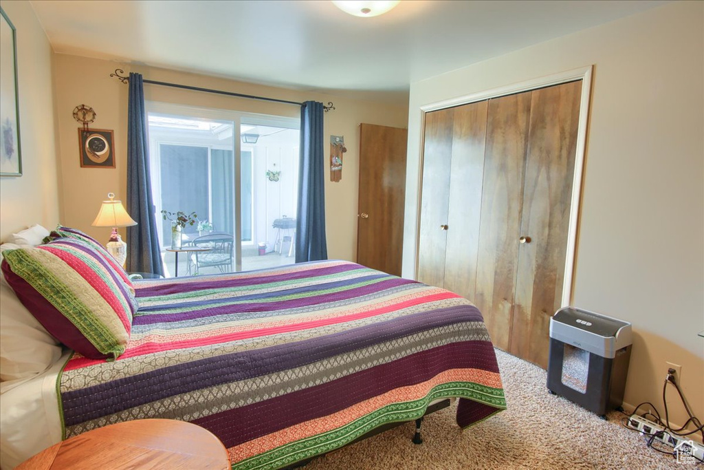 Carpeted bedroom featuring a closet and access to outside