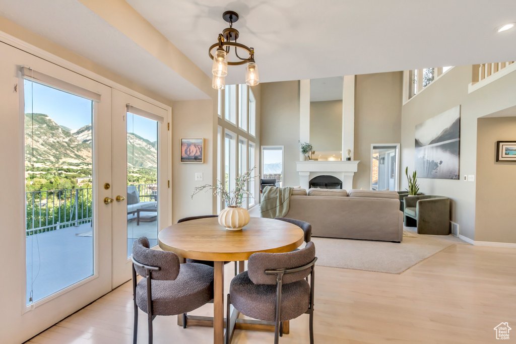 Dining space featuring light wood-type flooring, french doors, and a fireplace