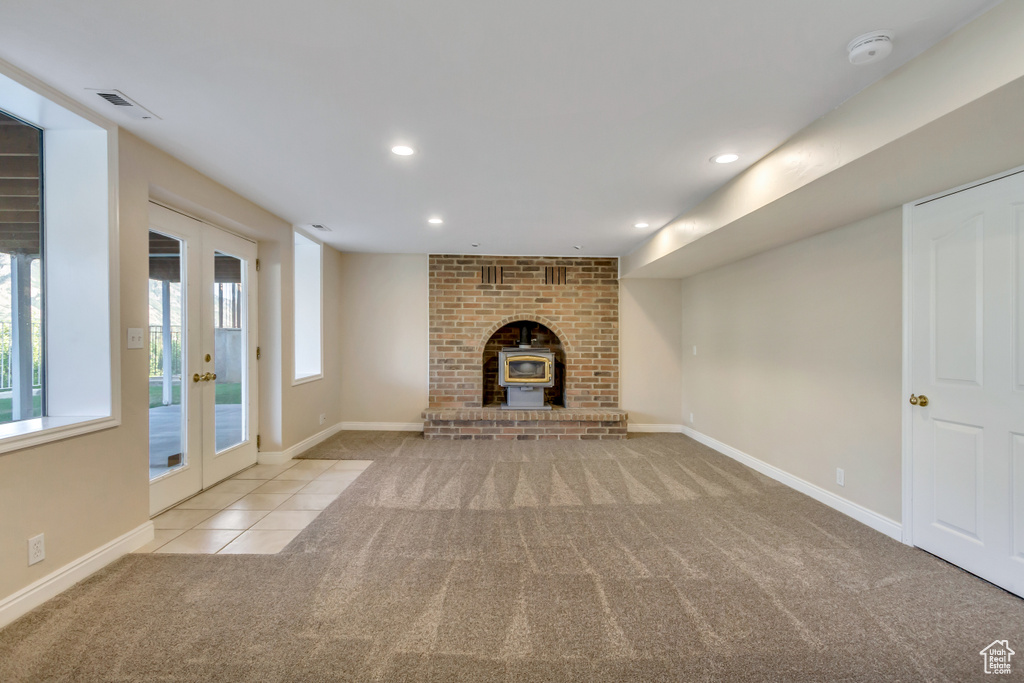 Unfurnished living room featuring carpet, french doors, recessed lighting, and tile patterned floors