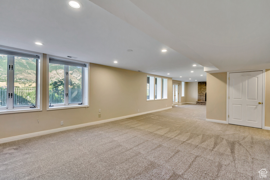 Below grade area with light colored carpet and recessed lighting