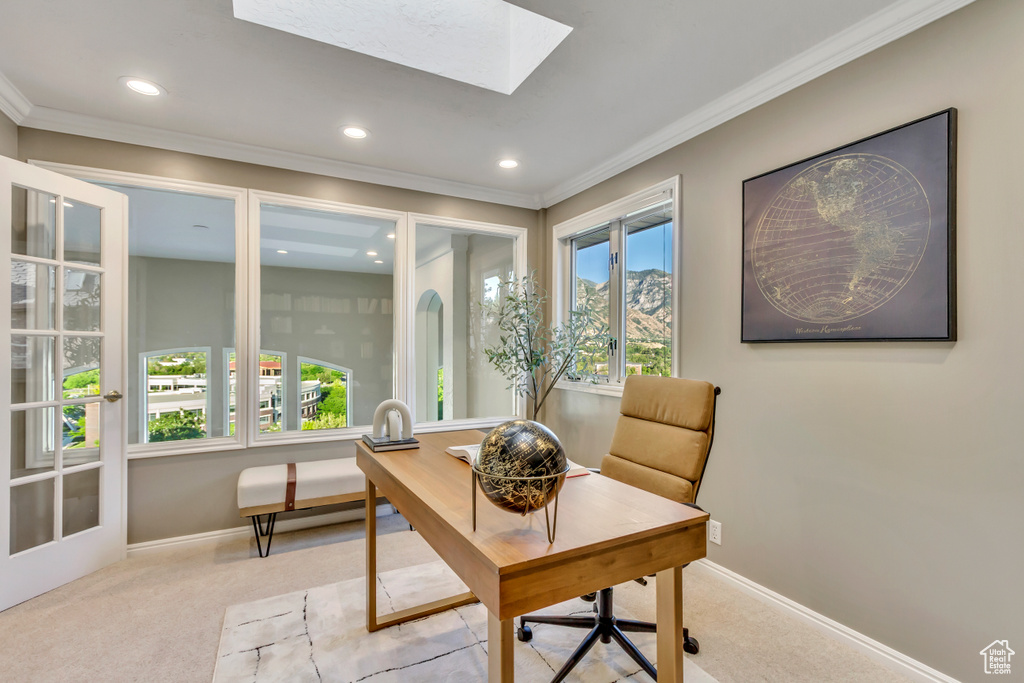 Carpeted home office with recessed lighting, ornamental molding, and a skylight