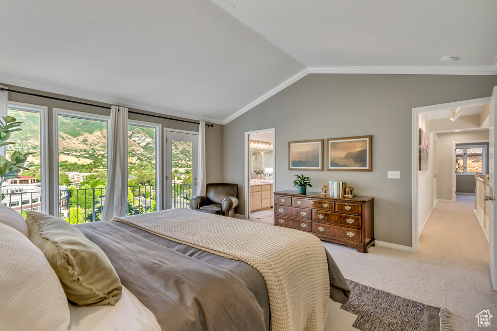 Bedroom featuring light carpet, vaulted ceiling, ensuite bathroom, crown molding, and access to exterior