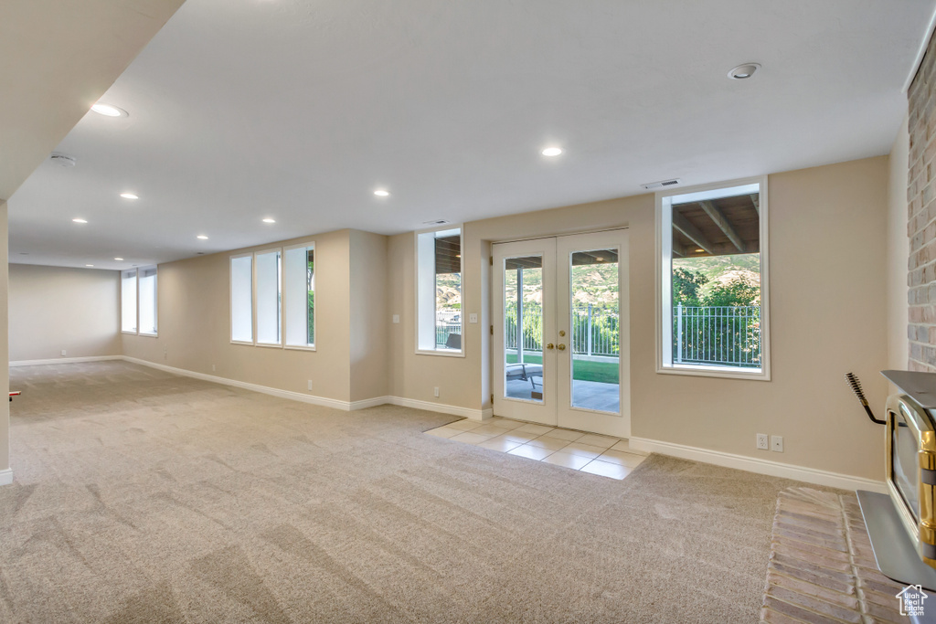Unfurnished living room featuring light colored carpet, french doors, and recessed lighting
